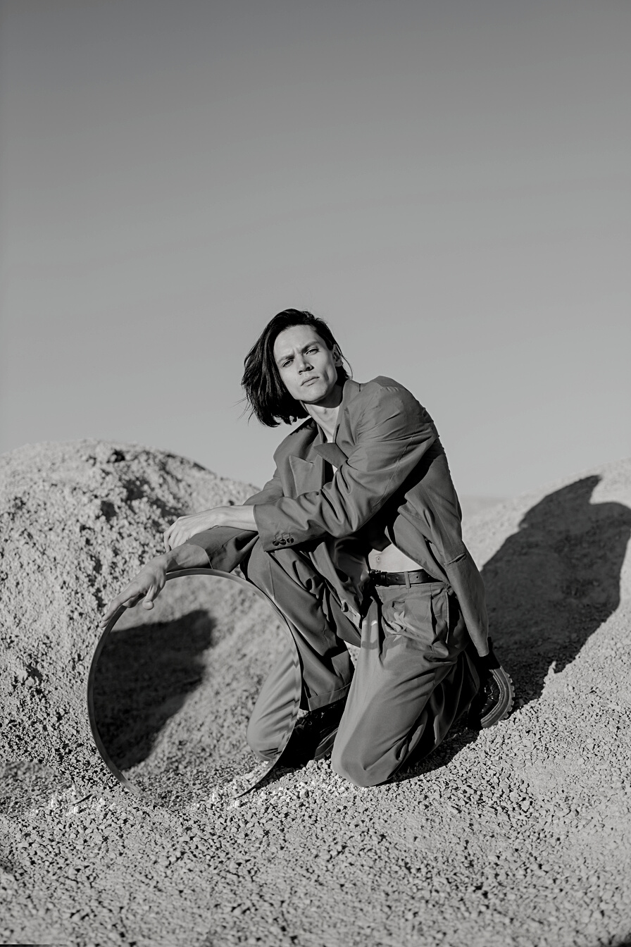 Woman in Green Jacket Sitting on Brown Rock