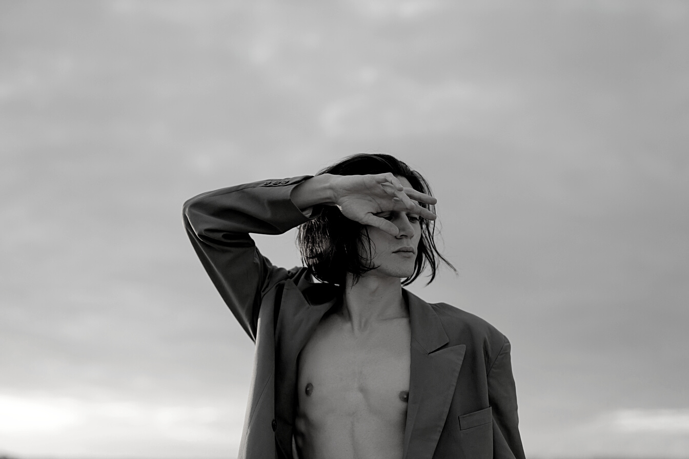 Woman in Gray Coat Covering Her Face With Her Hair