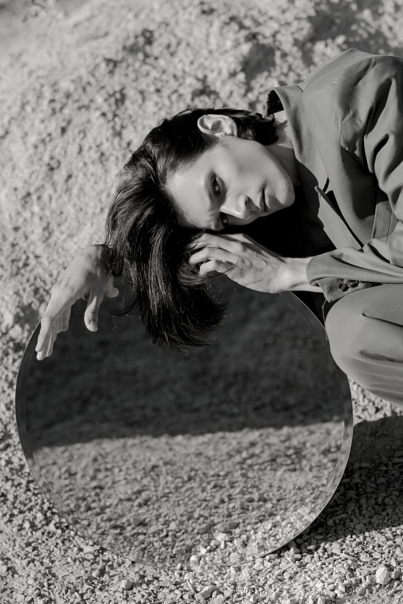 Woman in Green Jacket Lying on Sand